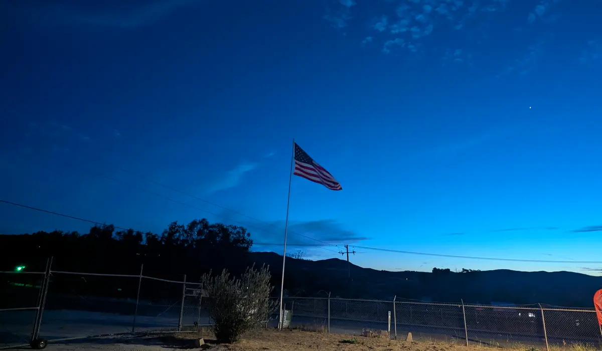 American flag and hills near Diamond Valley Market at dusk